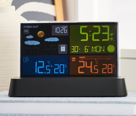 Eine Funk-Wetterstation mit LC-Farbdisplay steht auf einem Buch.