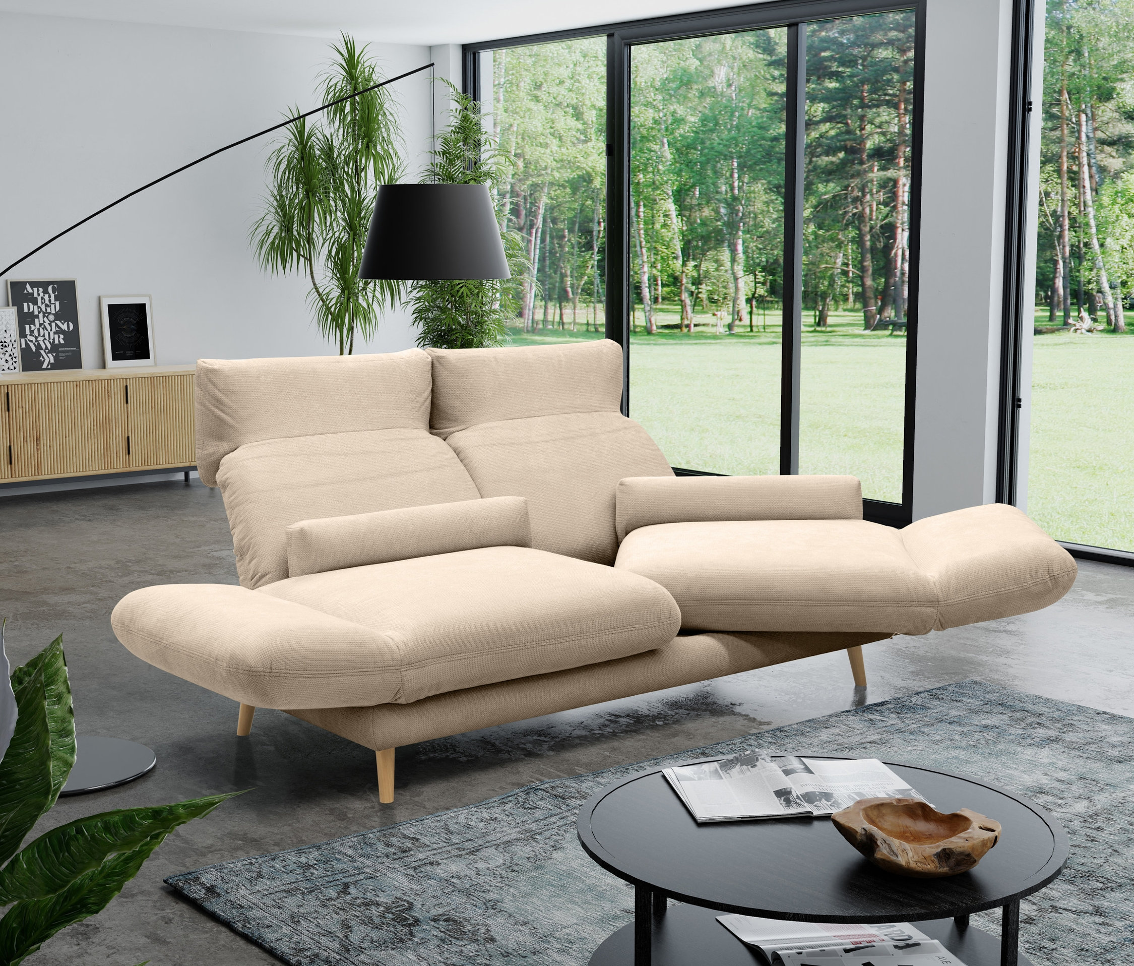 Ein cremefarbenes DOMO collection 2-Sitzer-Sofa »Malaga«, drehbar, in einem Wohnzimmer.