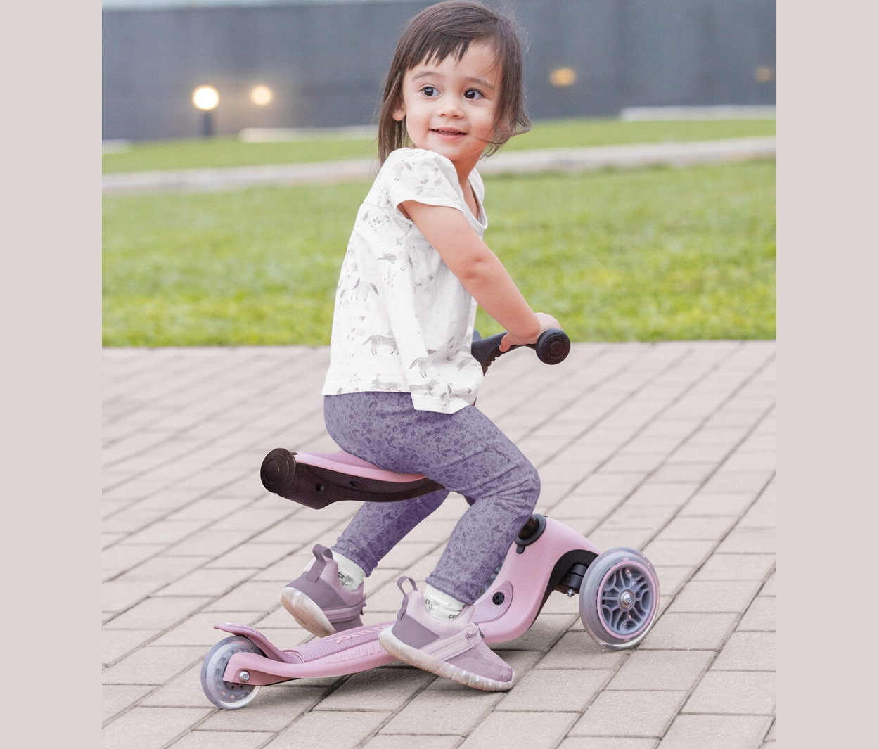 Mädchen sitzt auf einem GLOBBER 3in1 Roller »GO-UP Active Lights Eco«, Beere.