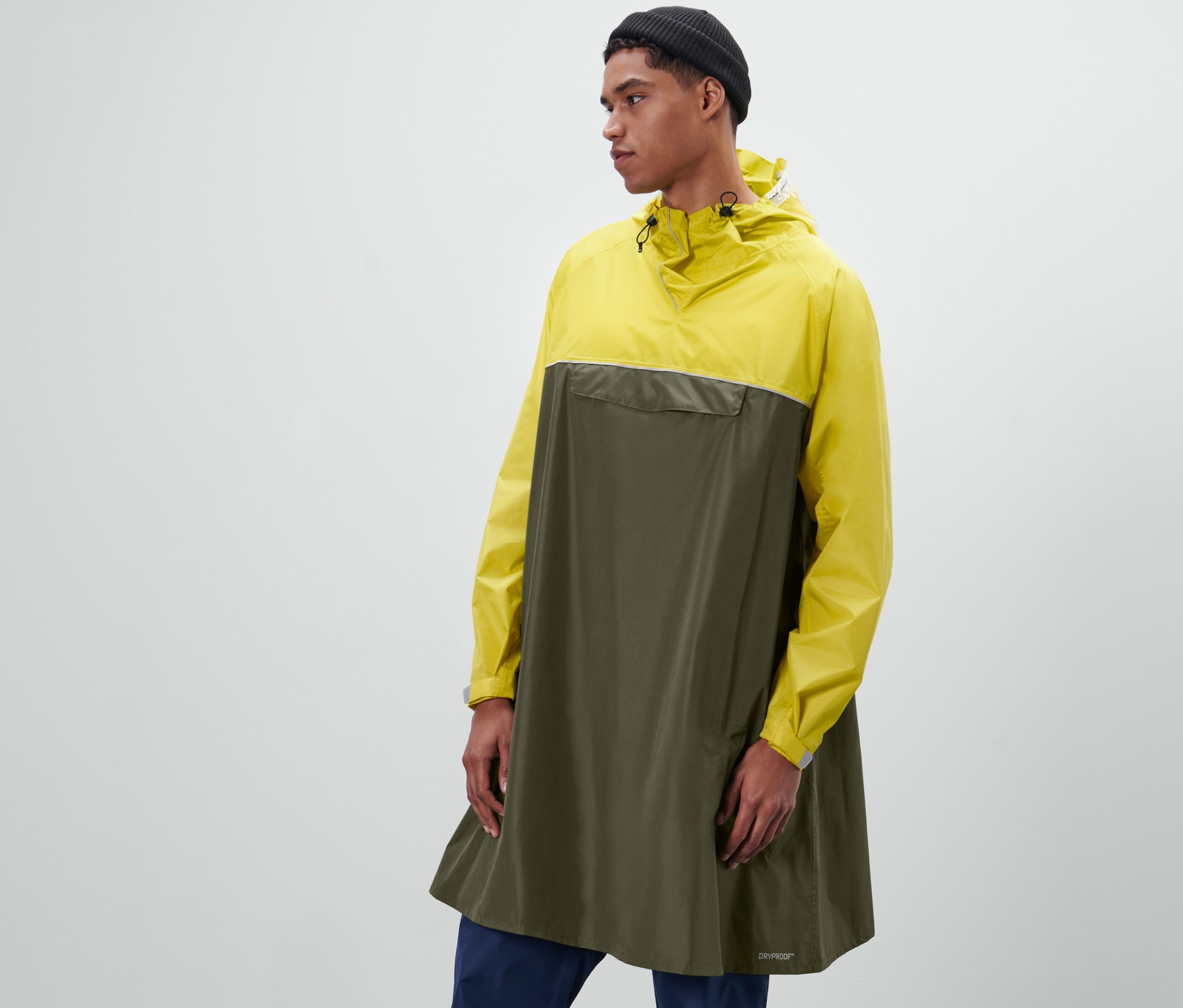 Mann posiert in Unisex-Regenponcho mit Ärmeln.