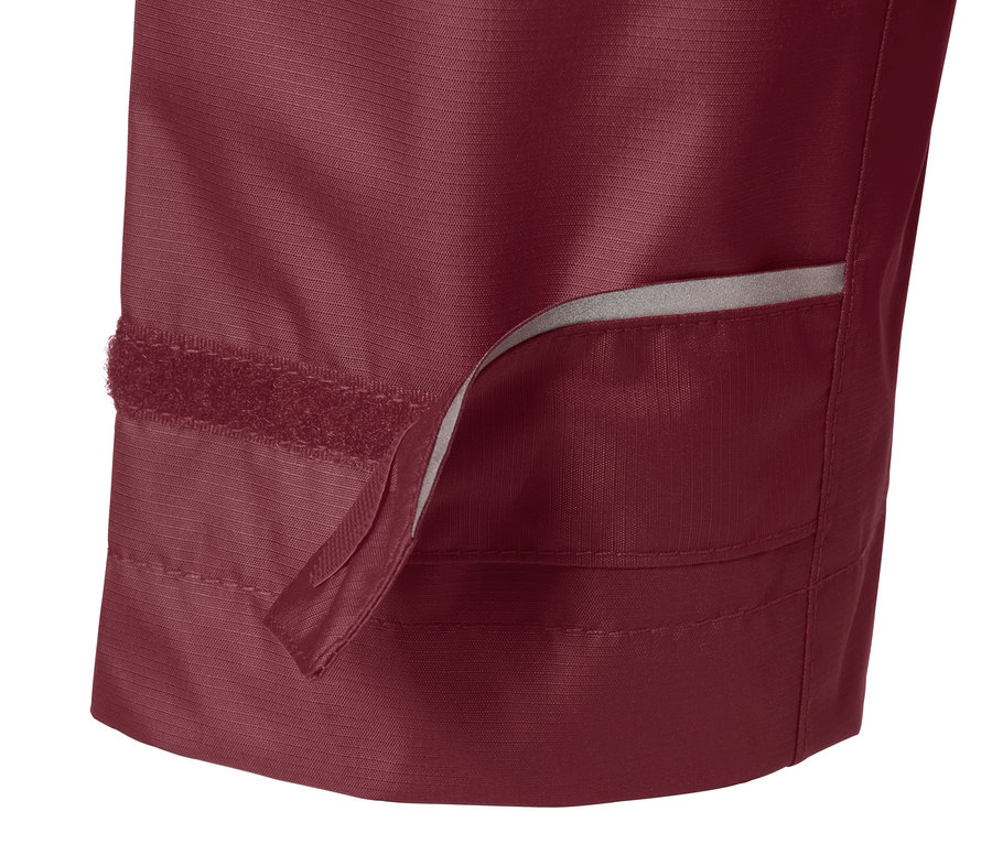 Detailaufnahme einer weinroten Regenjacke mit sichtbarem Klettverschluss.