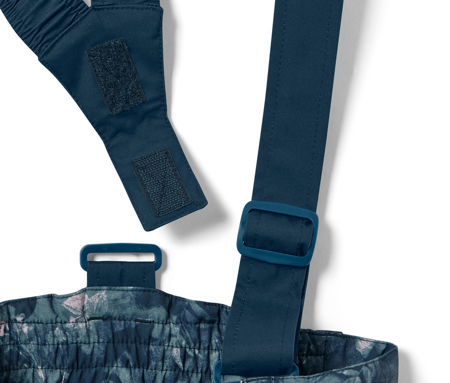 Detailaufnahme einer Kinder-Skihose mit Alloverprint, inklusive verstellbaren Trägern und Schnallen.