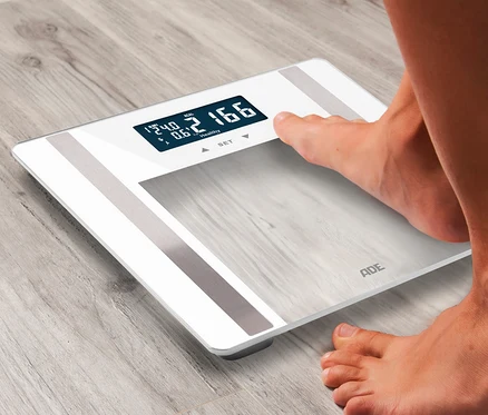 Person wiegt sich auf ADE digitaler Personenwaage.