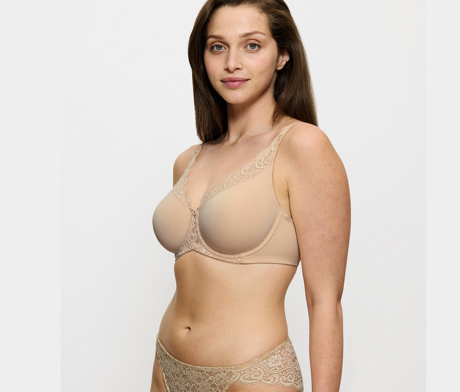 Frau trägt einen Triumph Amourette Minimizer-BH in Skin-Farbe und passenden Slip.
