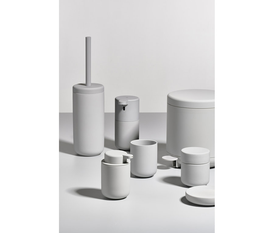 Sechs graue Badezimmerzubehörteile auf weißem Hintergrund, darunter ein ZONE DENMARK Seifenspender »Ume«, hellgrau.