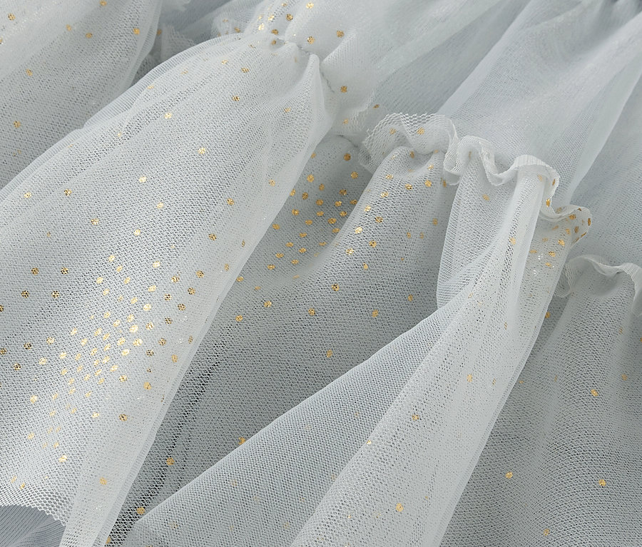 Detailaufnahme von hellblauem Tüllstoff mit goldenen Punkten und Rüschen.