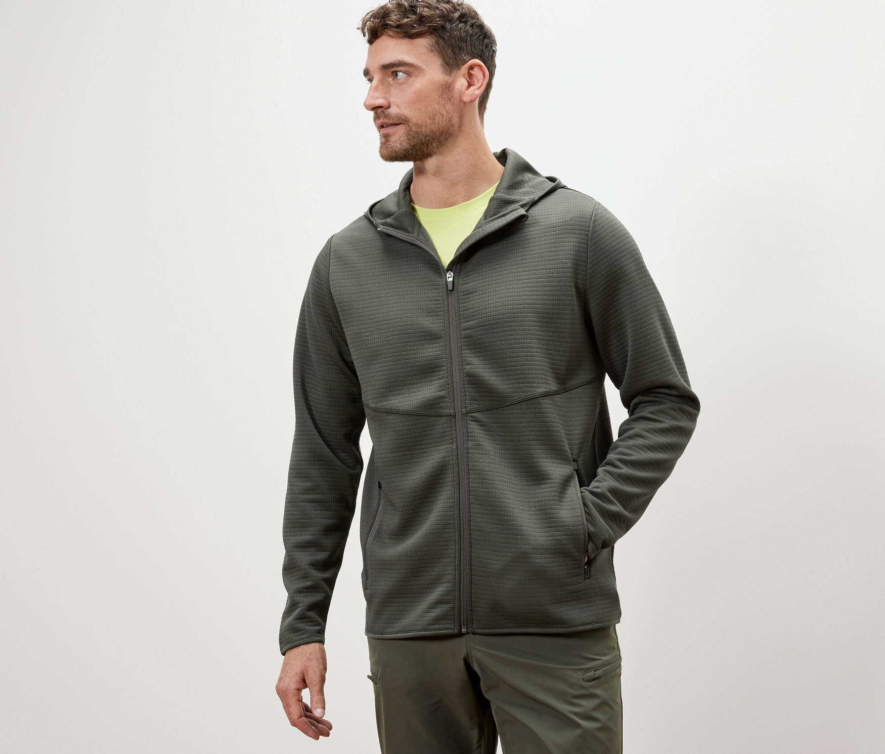 Mann trägt eine khakifarbene Funktionsjacke.