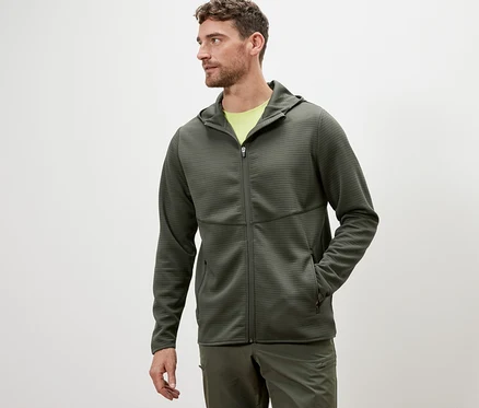 Mann trägt eine khakifarbene Funktionsjacke.
