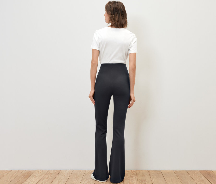 Frau von hinten in ausgestellten Leggings.