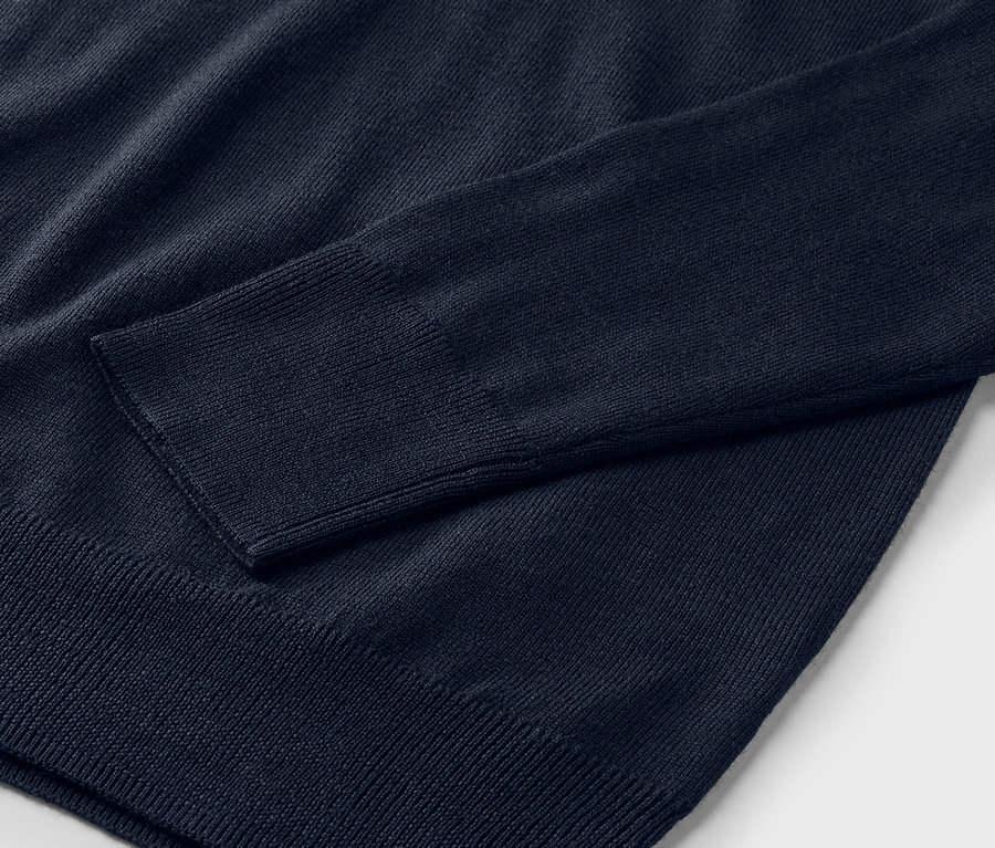 Detailaufnahme eines marineblauen Merino-Feinstrickpullovers.
