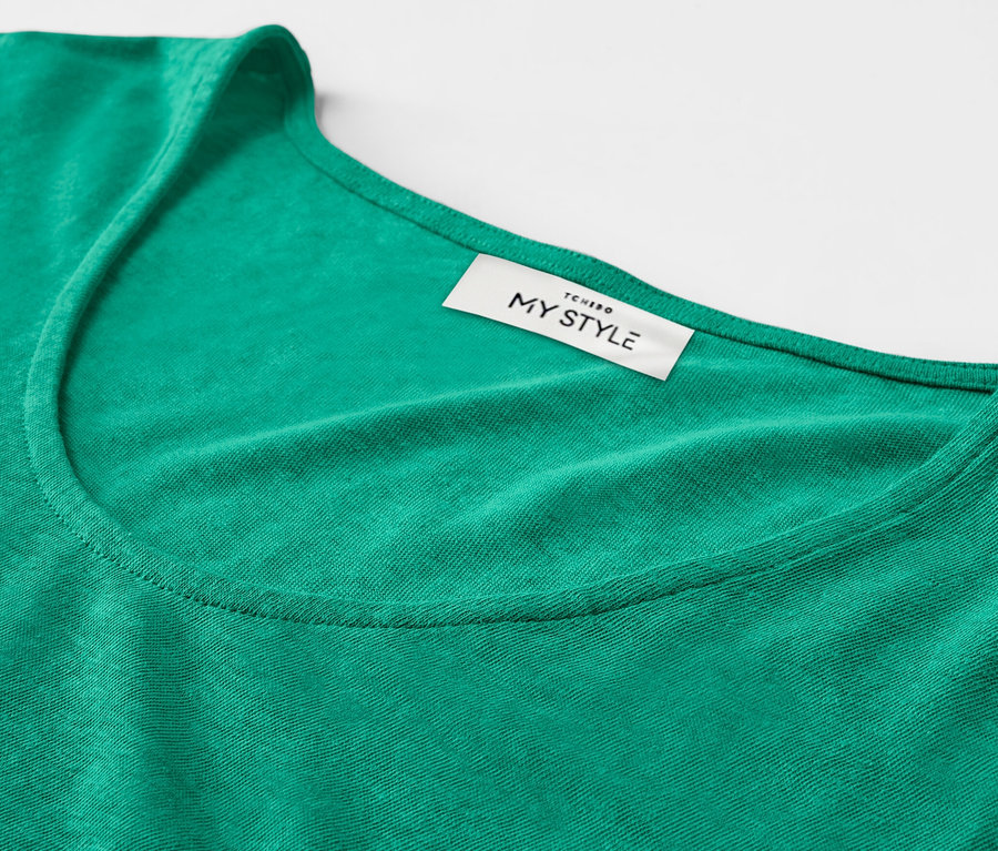 Detailansicht eines aquafarbenen Shirts aus Leinenmix mit sichtbarem Etikett.