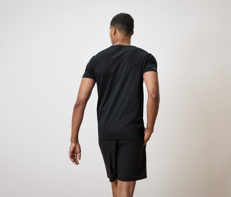 Mann von hinten in schwarzem T-Shirt und Shorts.