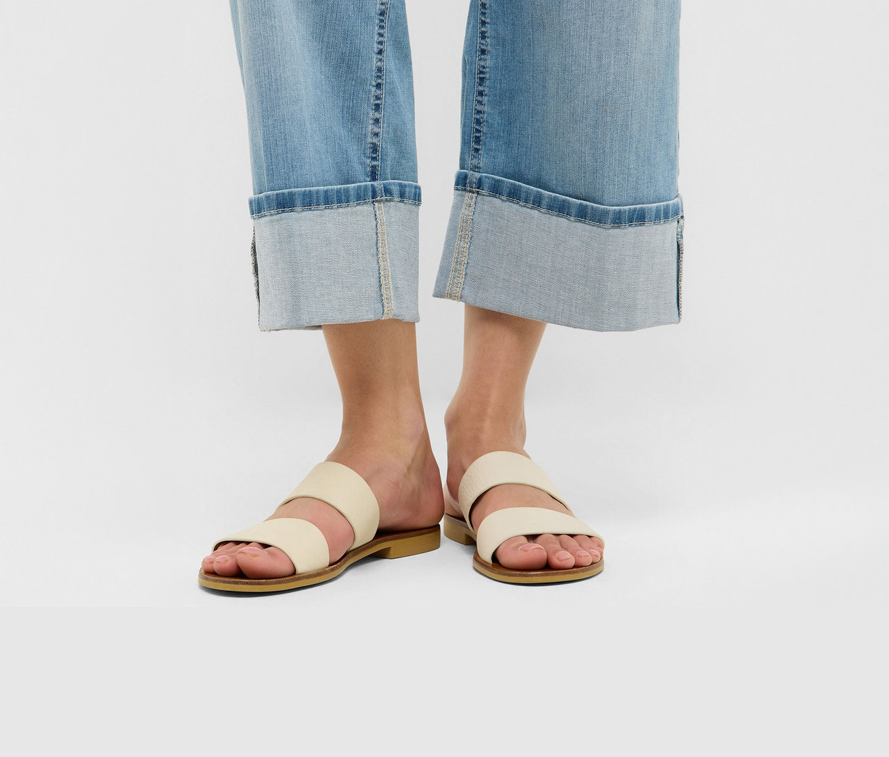 Beine in hellblauer Angels Jeans »Linn Turn Up«, Comfort Fit mit breiten Umschlägen und cremefarbenen Sandalen.