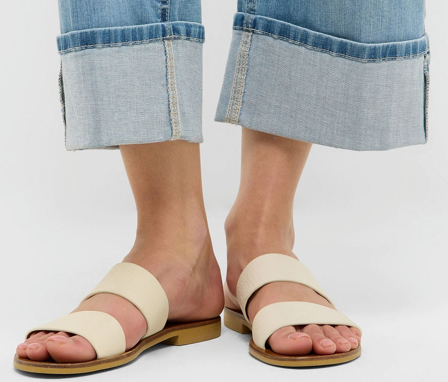 Beine einer Frau in Angels Jeans »Linn Turn Up«, Comfort Fit und Sandalen auf weißem Hintergrund.