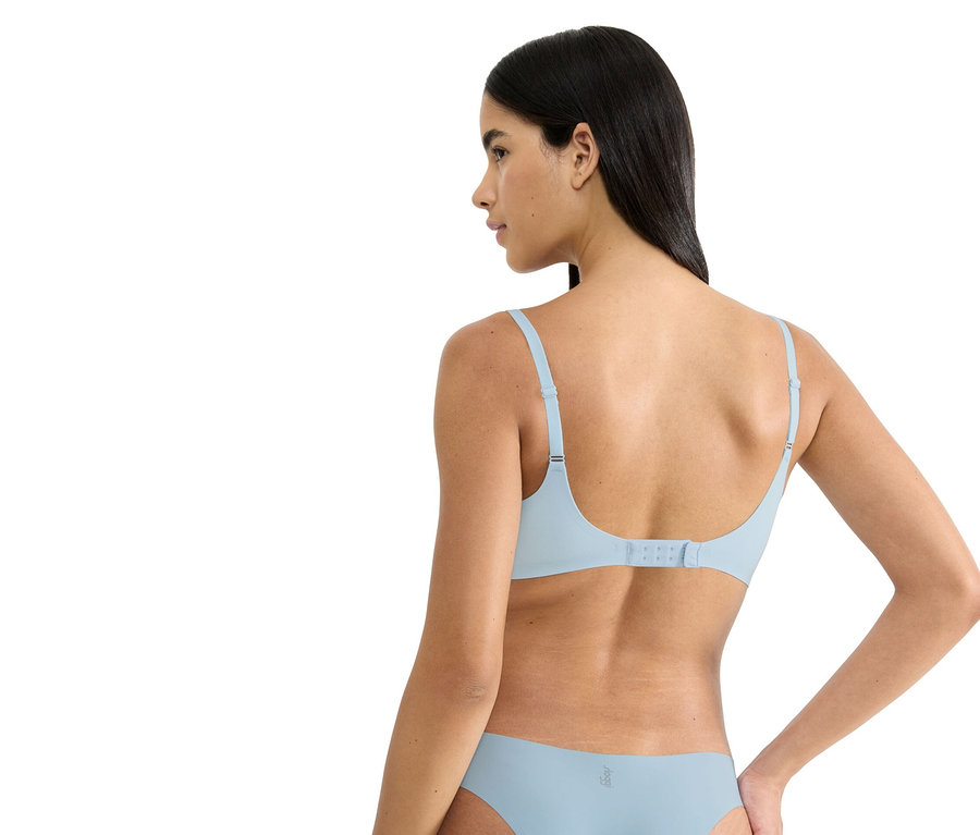 Frau von hinten, die einen hellblauen BH und Slip trägt.