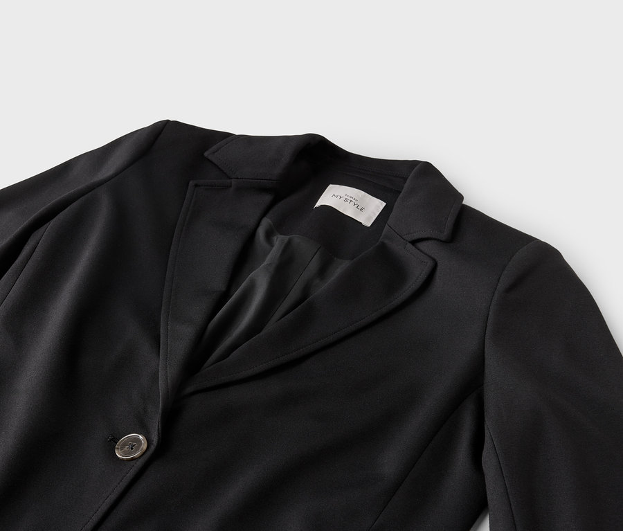 Nahaufnahme eines schwarzen Blazers mit Reverskragen und einem Knopf.