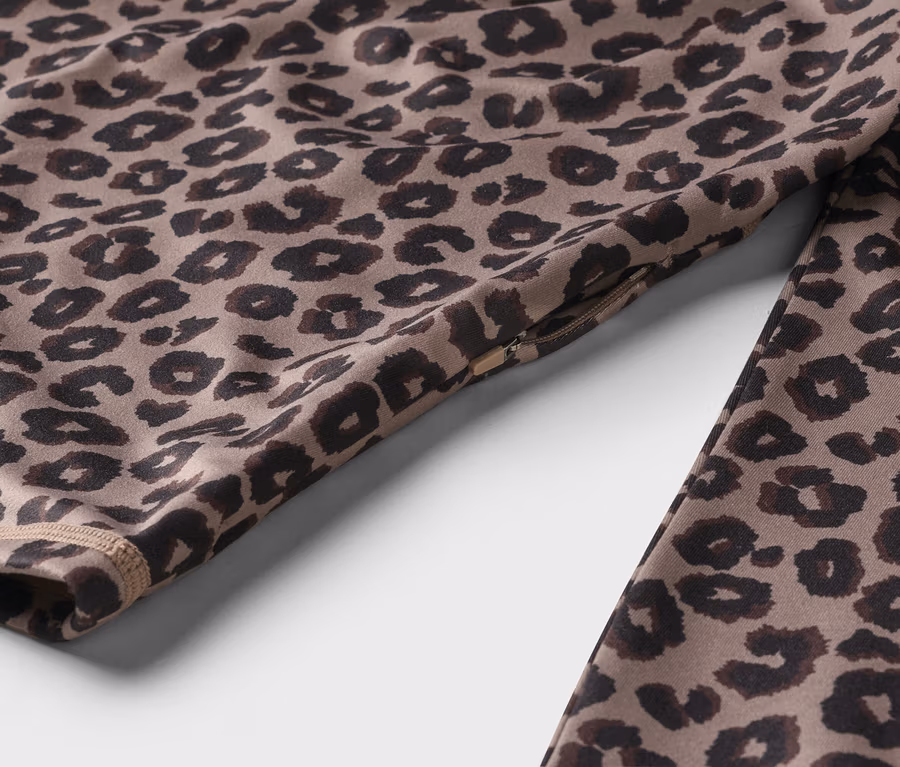Nahaufnahme von Sportbekleidung mit Leopardenmuster und Reißverschlussdetail.