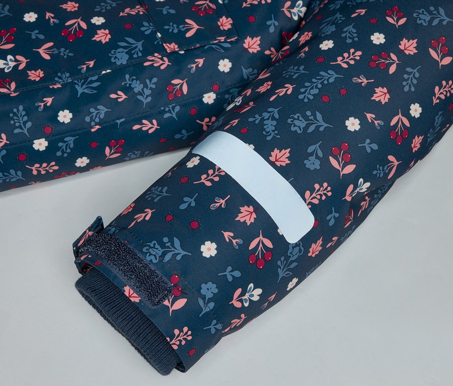 Nahaufnahme eines marineblauen Ärmels mit Blumenmuster, einem reflektierenden Streifen und einem Klettverschluss.