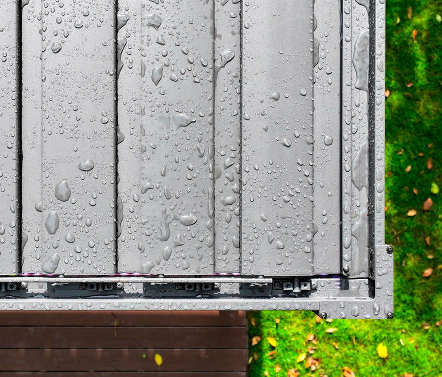 Draufsicht auf eine graue Terrassenüberdachung mit Wassertropfen nach einem Regen.