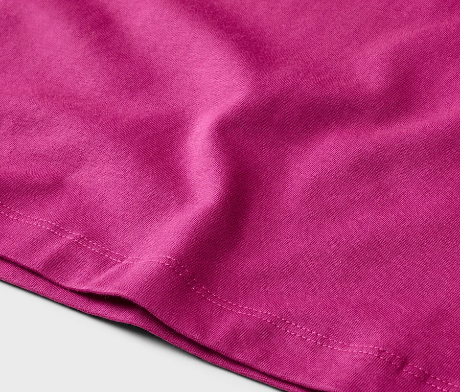 Nahaufnahme eines pinkfarbenen Stoffes mit sichtbarer Naht am unteren Rand.
