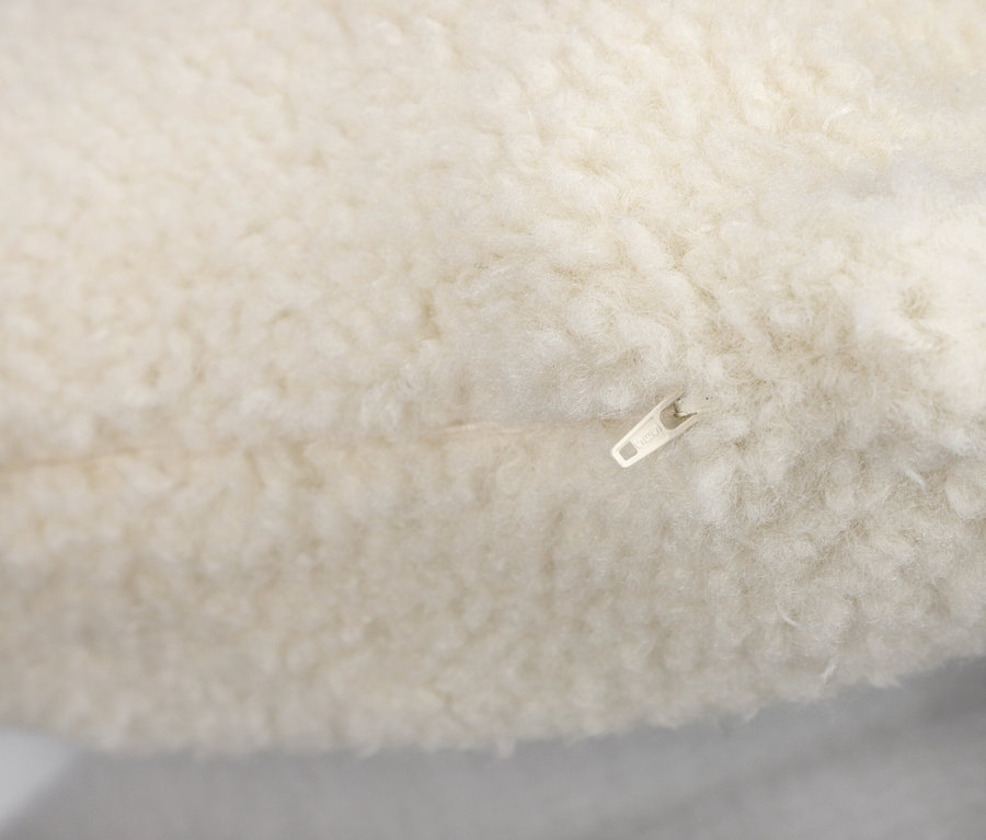 Nahaufnahme eines off-white SCHÖNER WOHNEN-Kollektion Dekokissenbezugs »TEDDY« mit sichtbarem Reißverschluss.
