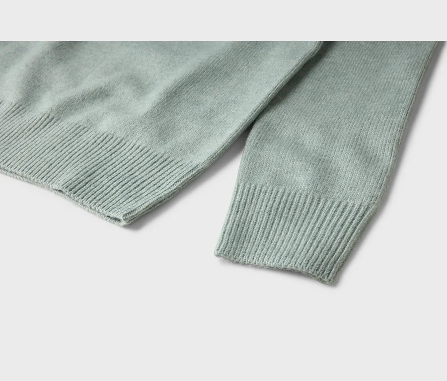 Helles, mintgrünes Strickoberteil mit gerippten Ärmelbündchen und Saum.