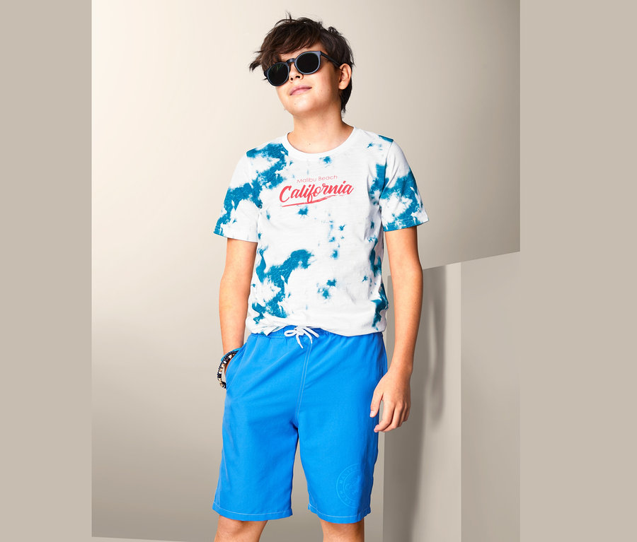 Junge mit T-Shirt und blauen Shorts.