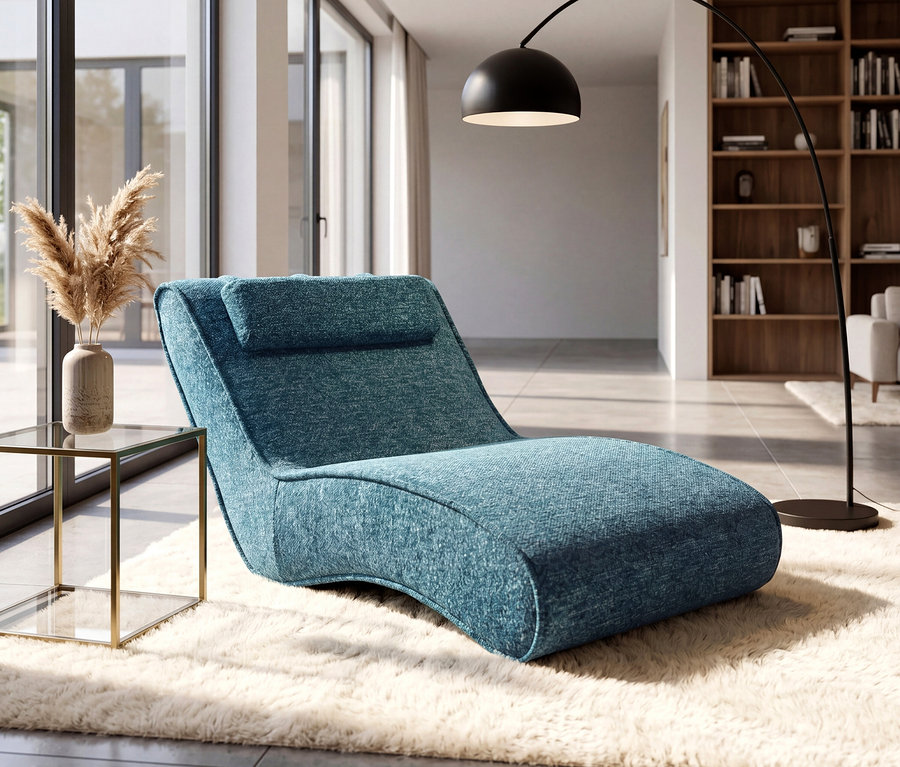 Ein modernes Wohnzimmer mit einer blauen Chaiselongue auf einem flauschigen weißen Teppich. Daneben steht ein Beistelltisch aus Glas und Gold mit Pampasgras in einer Vase. Eine schwarze Bogenstehlampe und große Fenster sind im Hintergrund zu sehen.