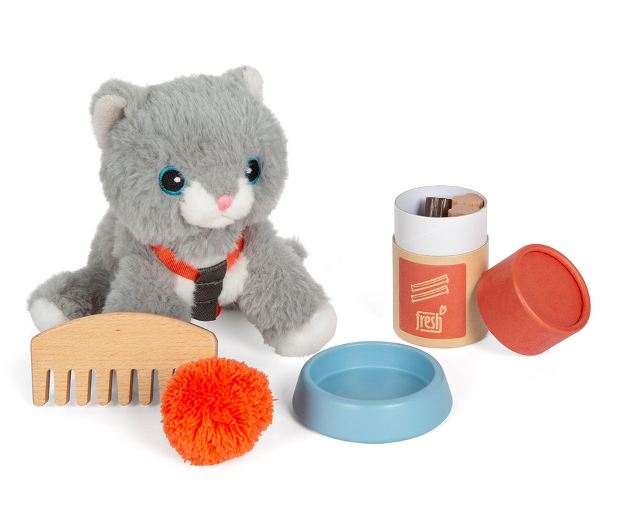 Graue small foot Plüschkatze mit Tasche, Kamm, orangefarbener Bommel, Napf und Behälter mit Deckel, alles auf weißem Hintergrund.