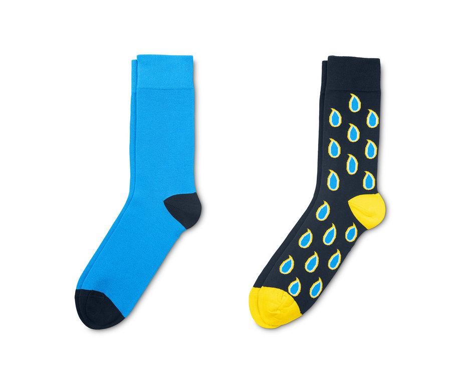 Zwei Paar Socken. Ein Paar ist blau mit dunkelblauer Spitze und Ferse. Das andere Paar ist dunkelblau mit gelber Spitze und Ferse und blauen Tropfen.
