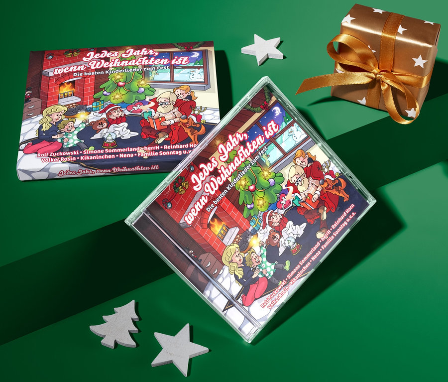 Auf grünem Grund liegen die CD »Jedes Jahr, wenn Weihnachten ist«, ein Geschenk und Dekorationen.