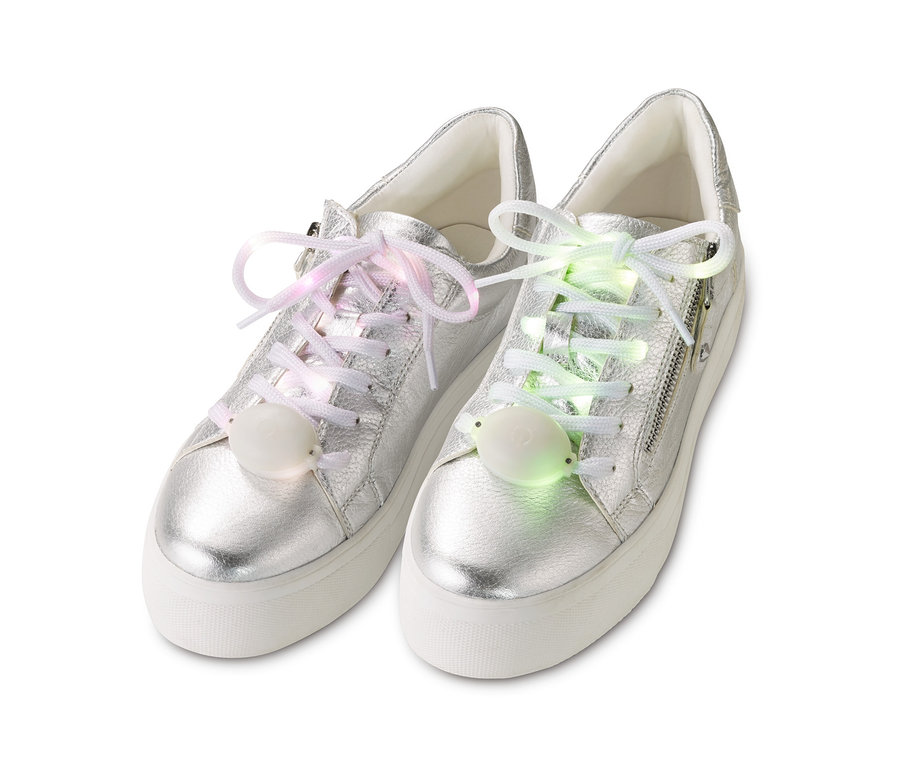 Silberne Turnschuhe mit LED-Leucht-Schnürsenkeln, einer mit rosa und der andere mit grünem Licht.