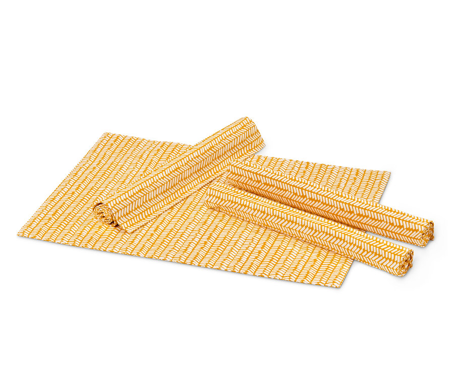 Gelbe 4 Wende-Platzsets, eines ausgebreitet und zwei gerollt.