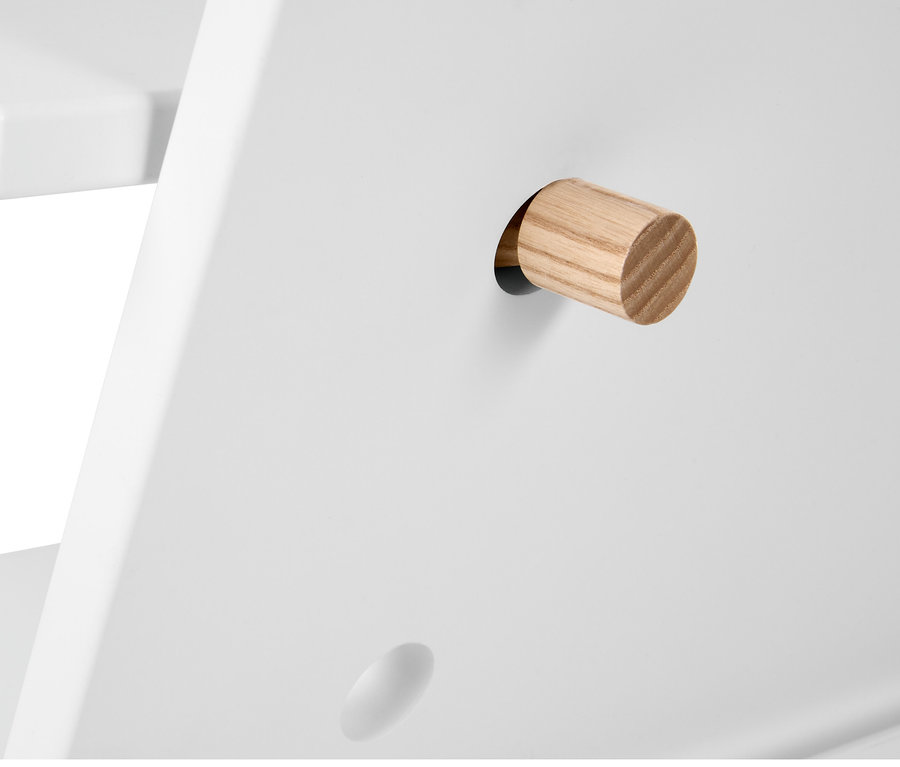 Detail eines weißen Möbelstücks mit einem Holzstift.