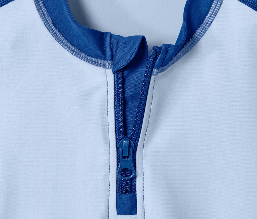 Detailaufnahme von einem blau-weissen UV-Schutz-Kombi mit Reissverschluss.