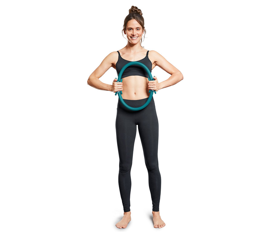 Frau hält einen Pilatesring.