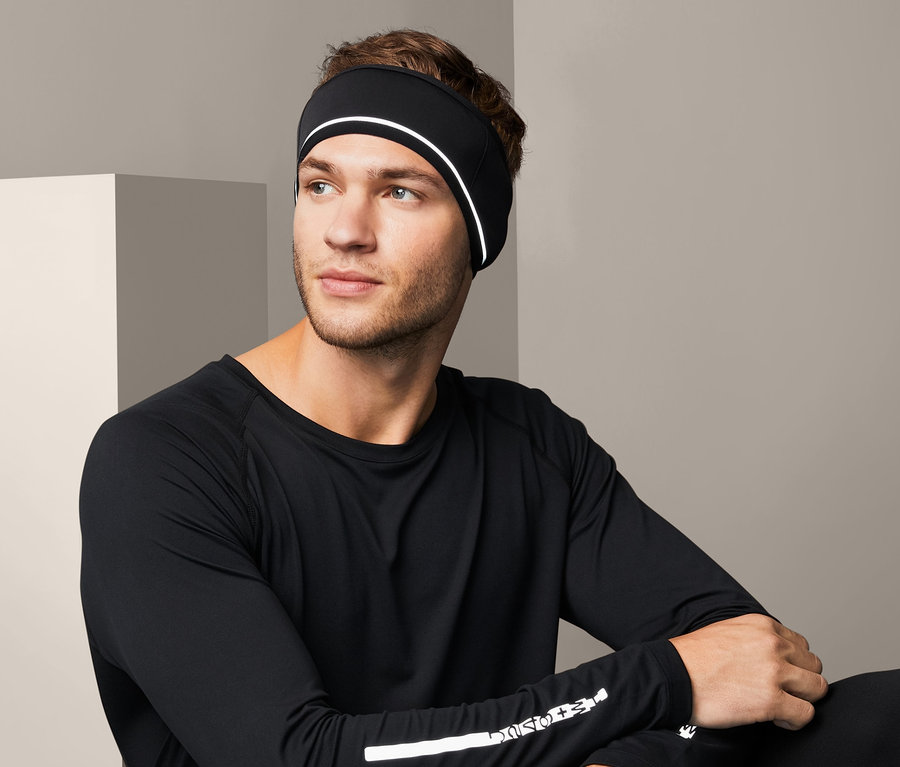 Mann sitzt, trägt ein Windprotection-Stirnband in Schwarz.