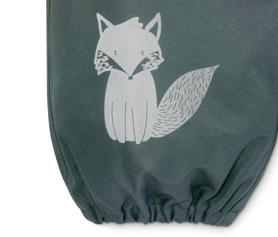 Detailaufnahme einer grünen Regenhose mit Trägern und einem Fuchs-Motiv.