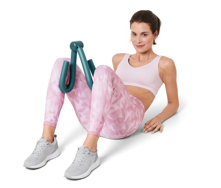 Frau sitzt und benutzt Arm-und-Bein-Trainer.