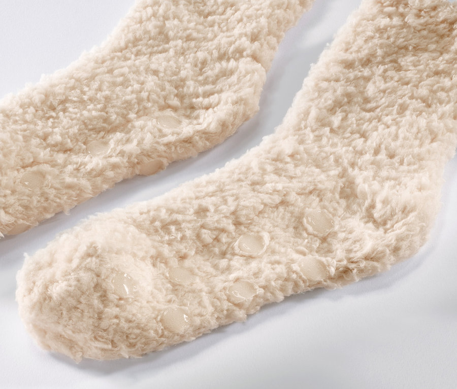 Detail von zwei Paar Teddy-Kuschelsocken in Beige.