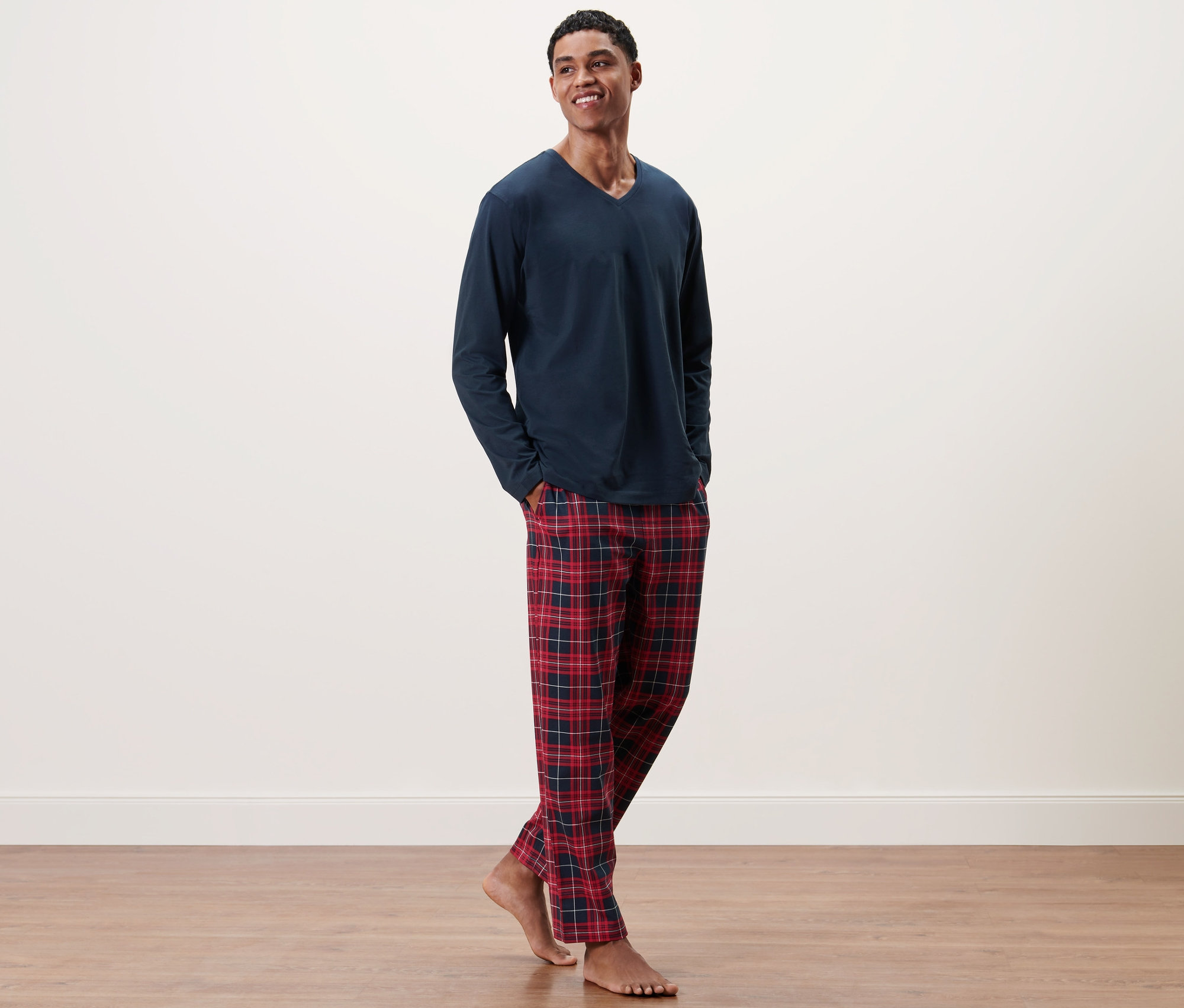 Mann trägt Pyjama mit karierter Hose.