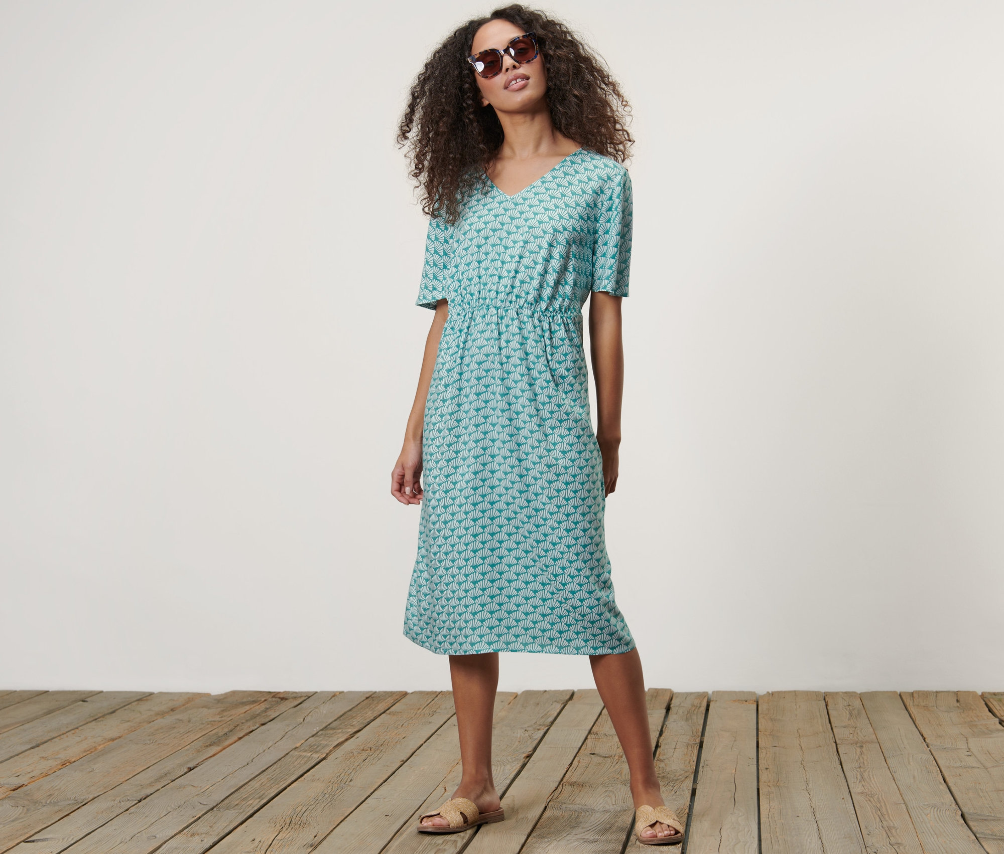 Frau posiert in einem Kleid mit Print.