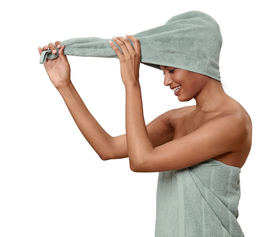 Frau bindet ein Turban-Handtuch um ihre Haare.