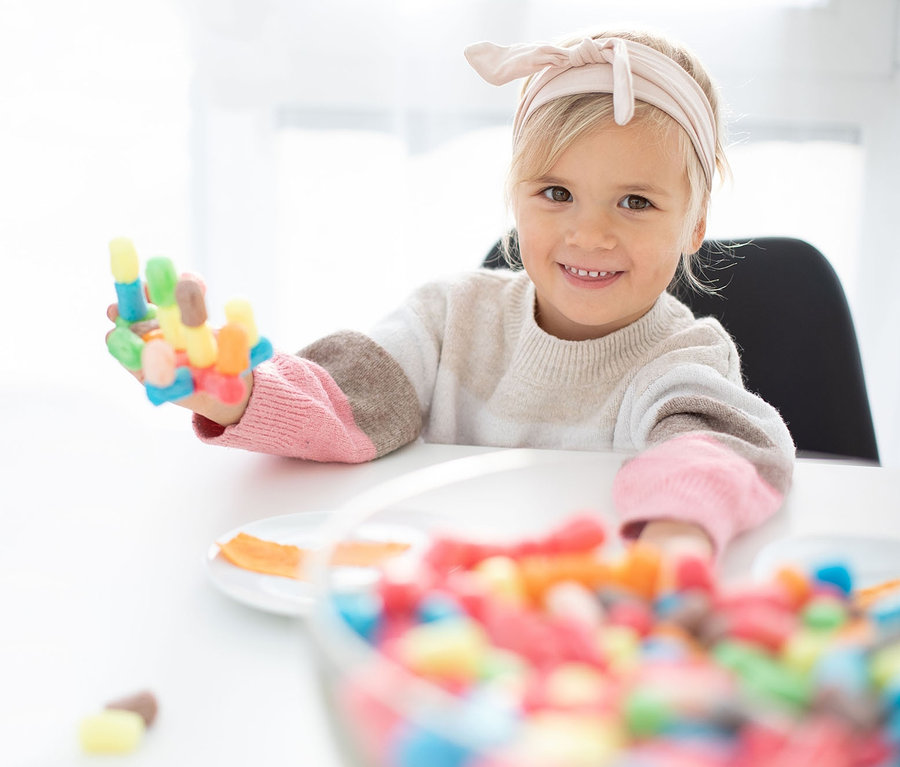 Mädchen hält ein buntes PlayMais®-Set in der Hand.