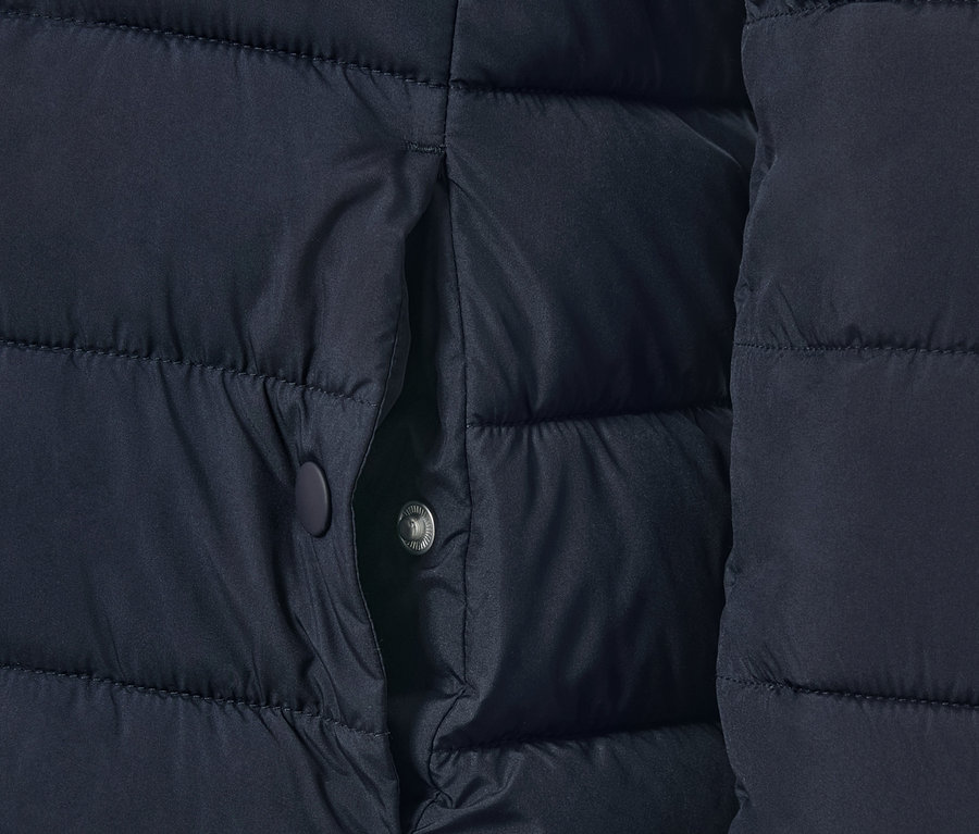 Detailansicht einer dunkelblauen Steppjacke mit Tasche.