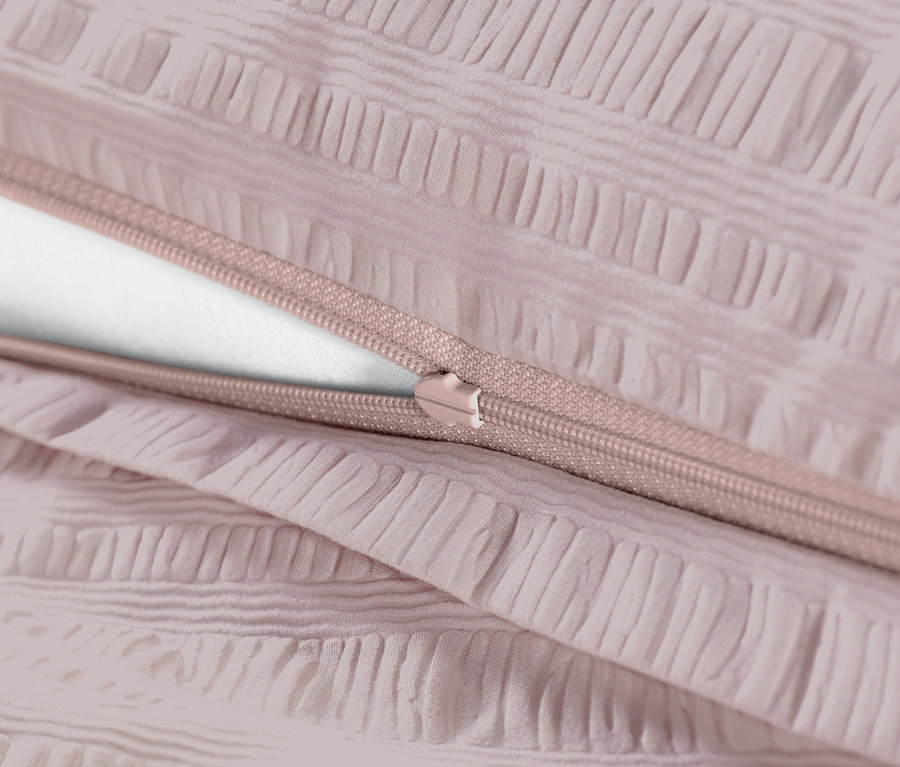 Detailansicht von rosafarbener Seersucker-Bettwäsche mit Reißverschluss.