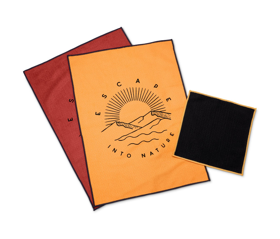 Ein Geschirrtuch-Set bestehend aus einem orangefarbenen Tuch mit Aufdruck und je einem roten und schwarzen Tuch.