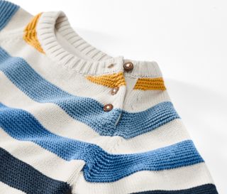 Detailaufnahme eines Kinder-Strickpullovers mit blauen, weißen und gelben Streifen.