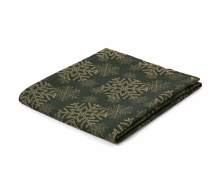 Eine grüne Jacquard-Tischdecke mit Schneeflockenmuster, gefaltet auf einem weißen Hintergrund.
