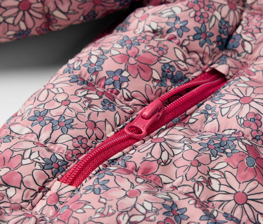 Detailaufnahme einer Kinder-Steppjacke, geblümt, mit offenem Reißverschluss.